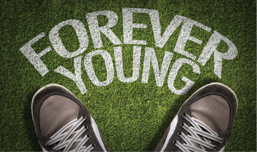 Top View of Sneakers on the grass with the text: Forever Young