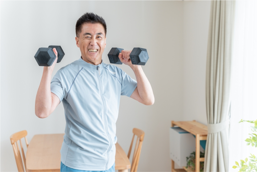 Senior Asian man doing strength training with dumbbells